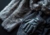 Luxurious fur stole, knitted shawl, and leather gloves on dark background.