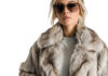 Front view mid body shot of an extremely beautiful female Caucasian model wearing a chinchilla fur coat with sunglasses on a white transparent background