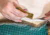 furrier cuts the edge of fur pelt by knife